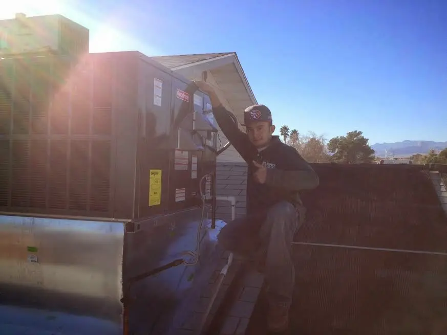 HVAC technician performing Heat Pump Repair on a rooftop unit in Monument